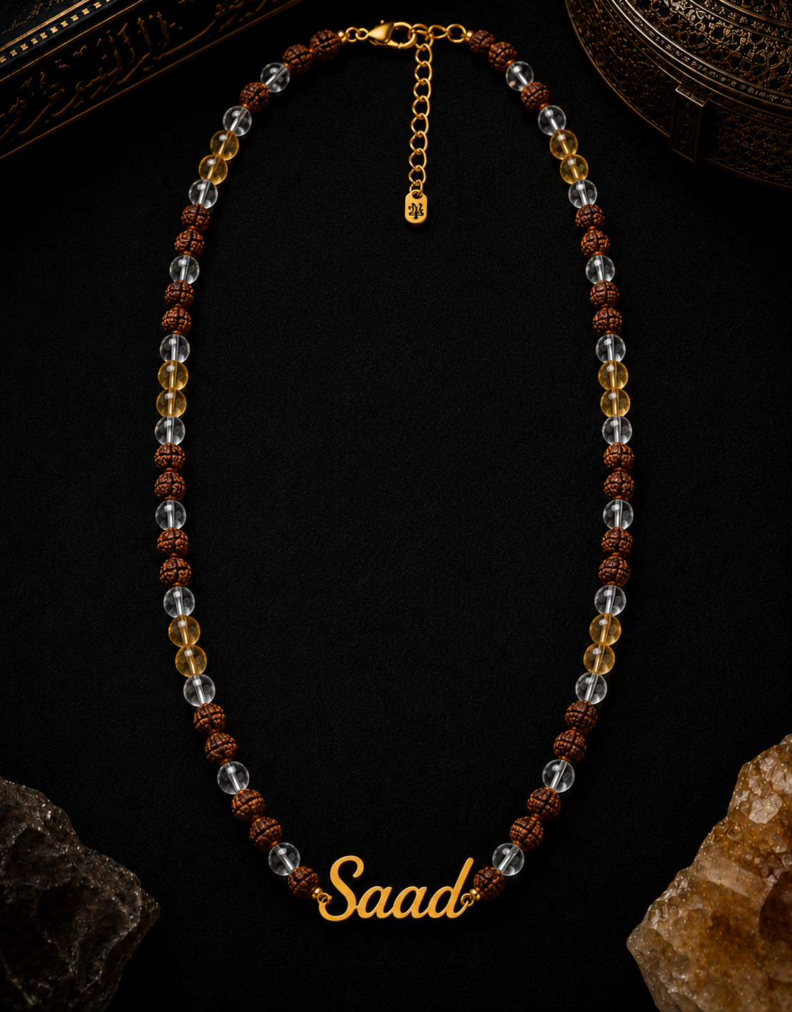 Necklace with beads and 'Saad' engraving on a dark background