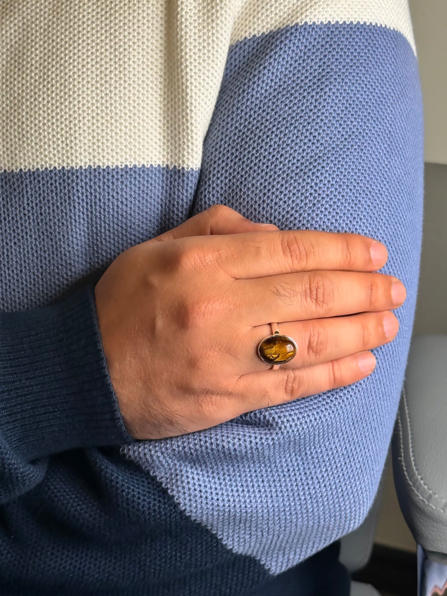 Close up of Tiger Eye gemstone ring on a man’s hand