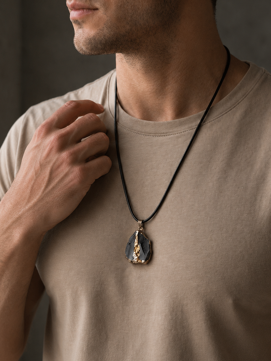 Man wearing a necklace with a pendant against a neutral background