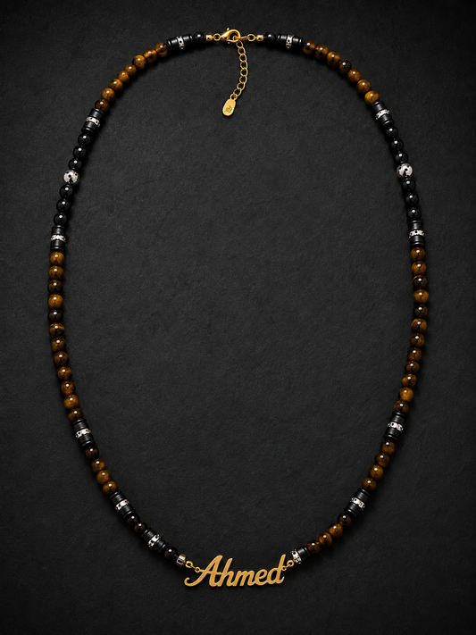 Necklace with beads and a gold nameplate 'Ahmet' on a dark background