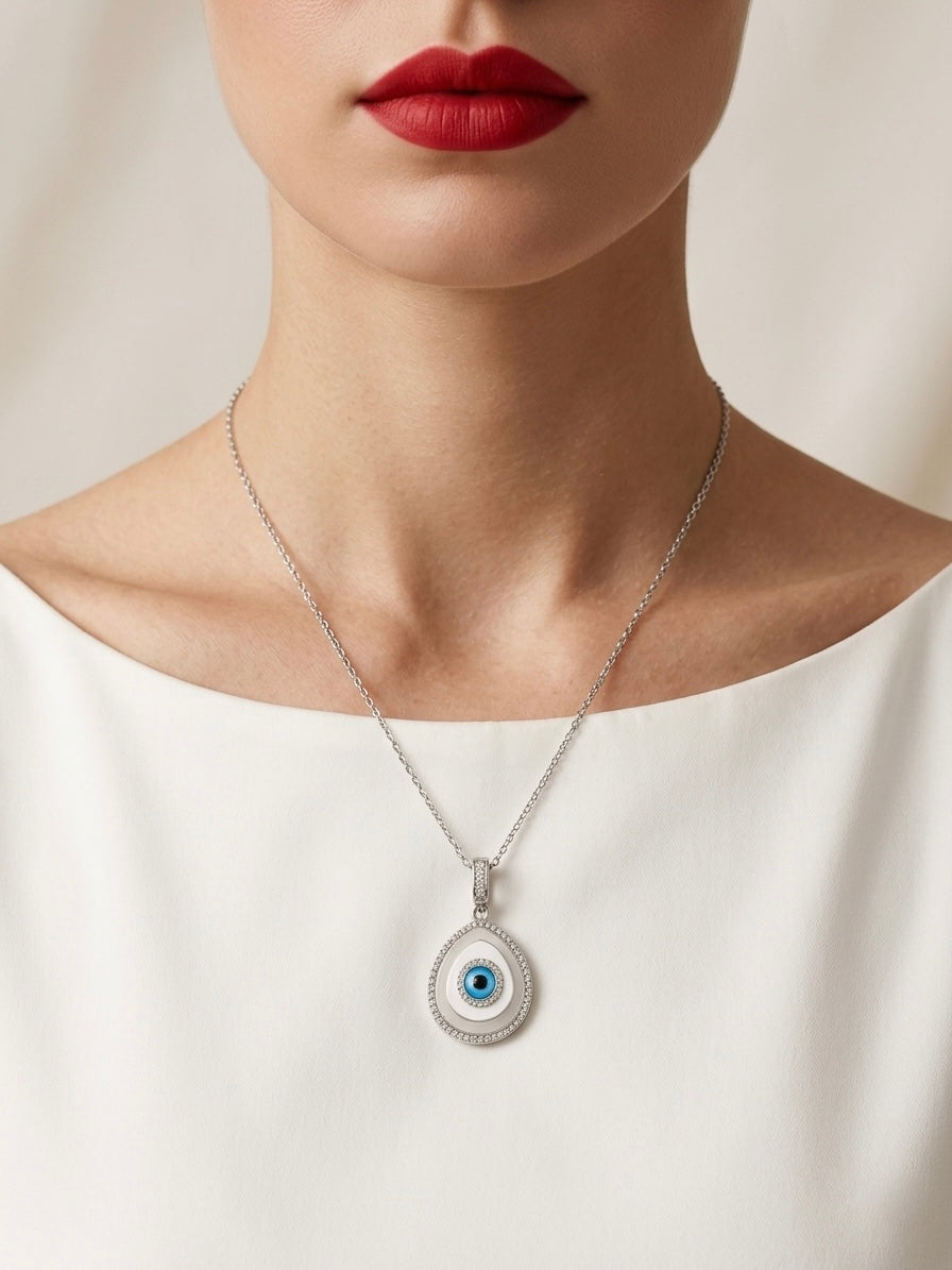 Necklace with an eye-shaped pendant worn by a person against a neutral background