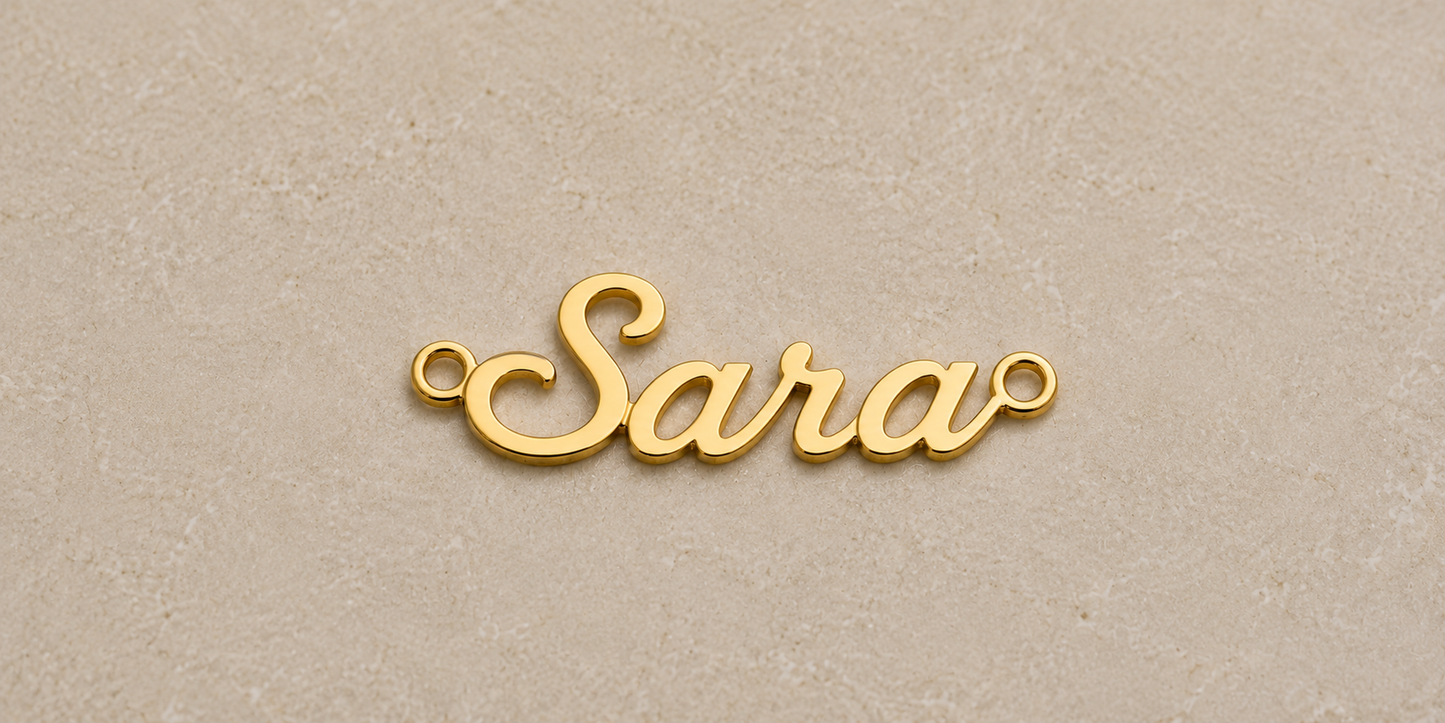 Gold 'Sara' pendant on a beige background