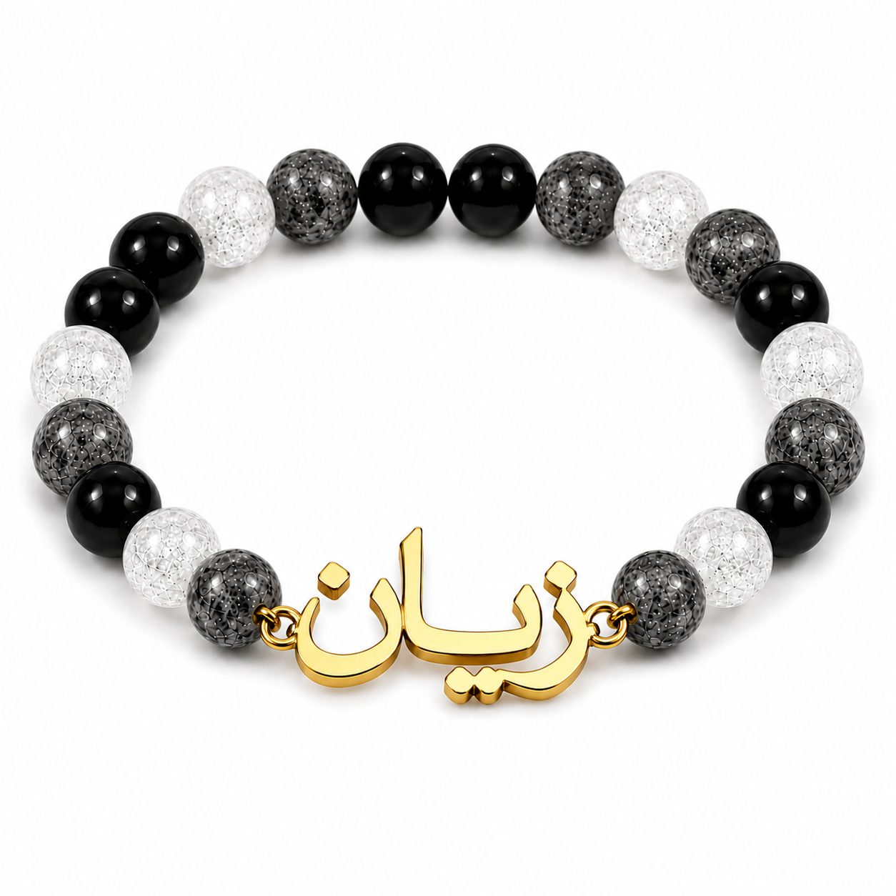 Bracelet with black, gray, and white beads and a gold charm on a white background