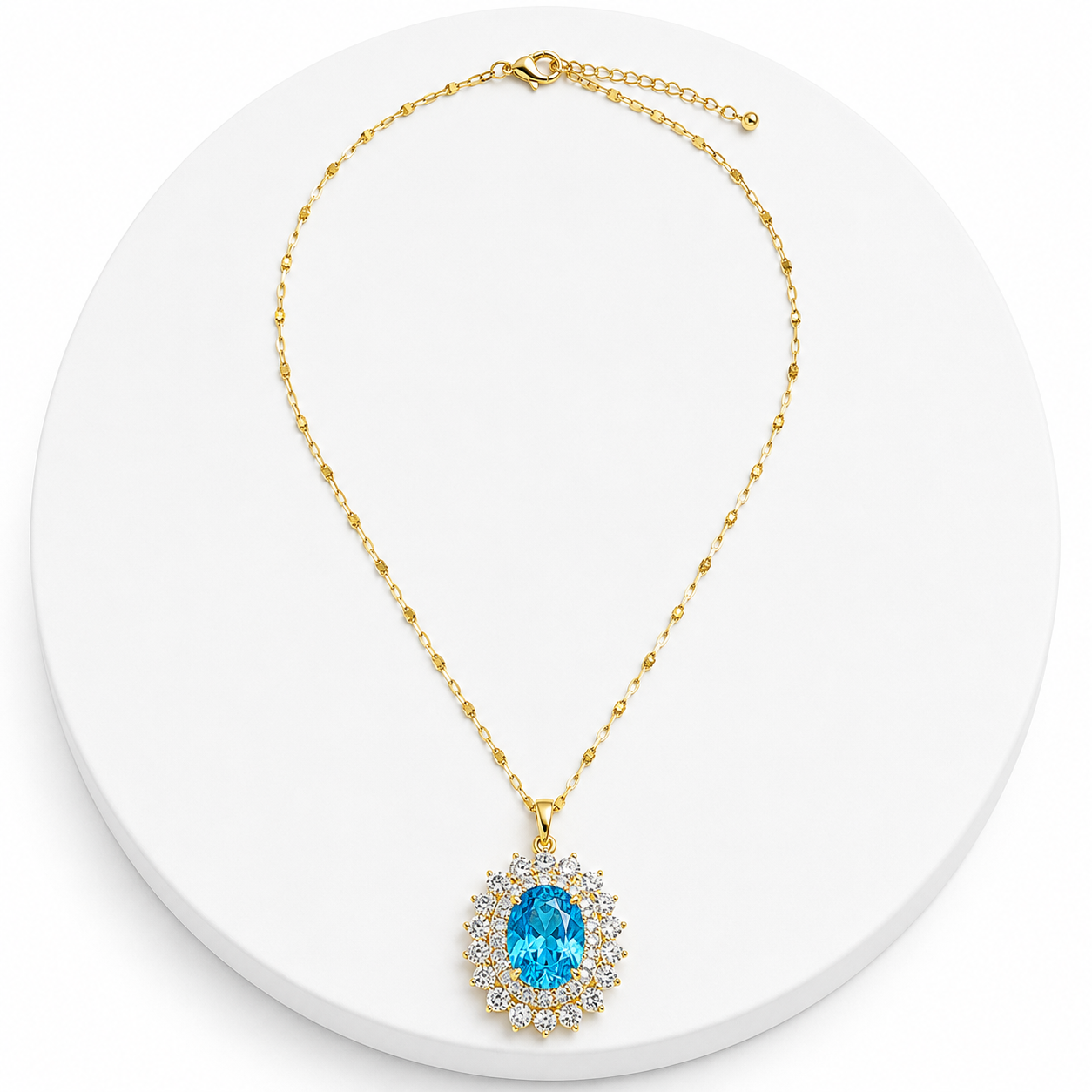 Gold necklace with a blue gemstone pendant on a white background