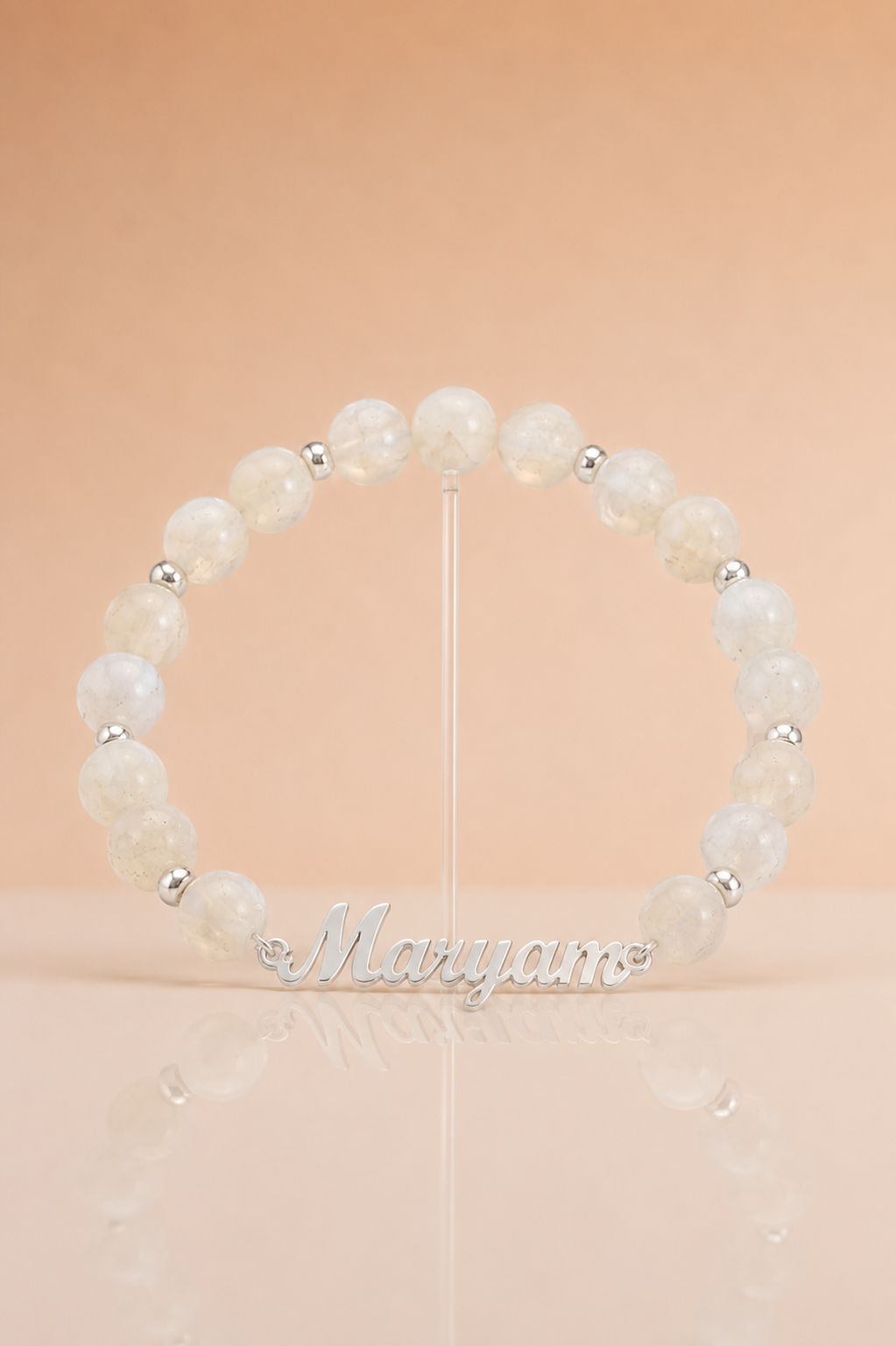 Pearl bracelet with silver beads on a stand against a beige background