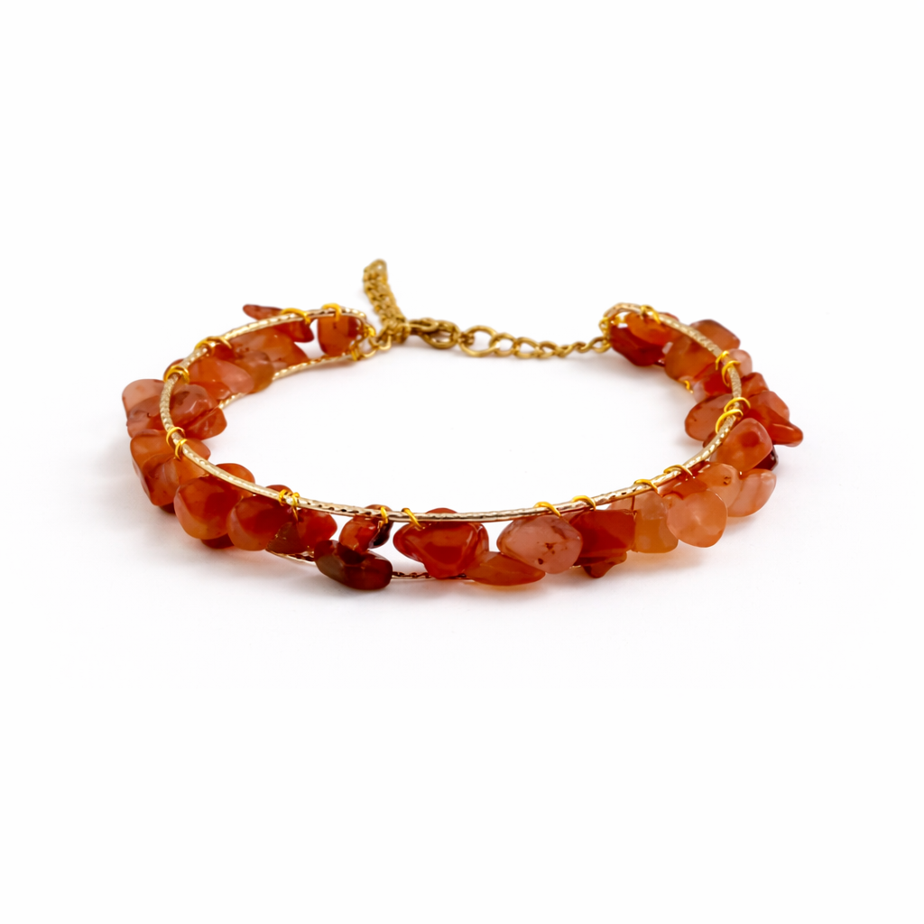 Bracelet with orange beads and gold chain on a white background