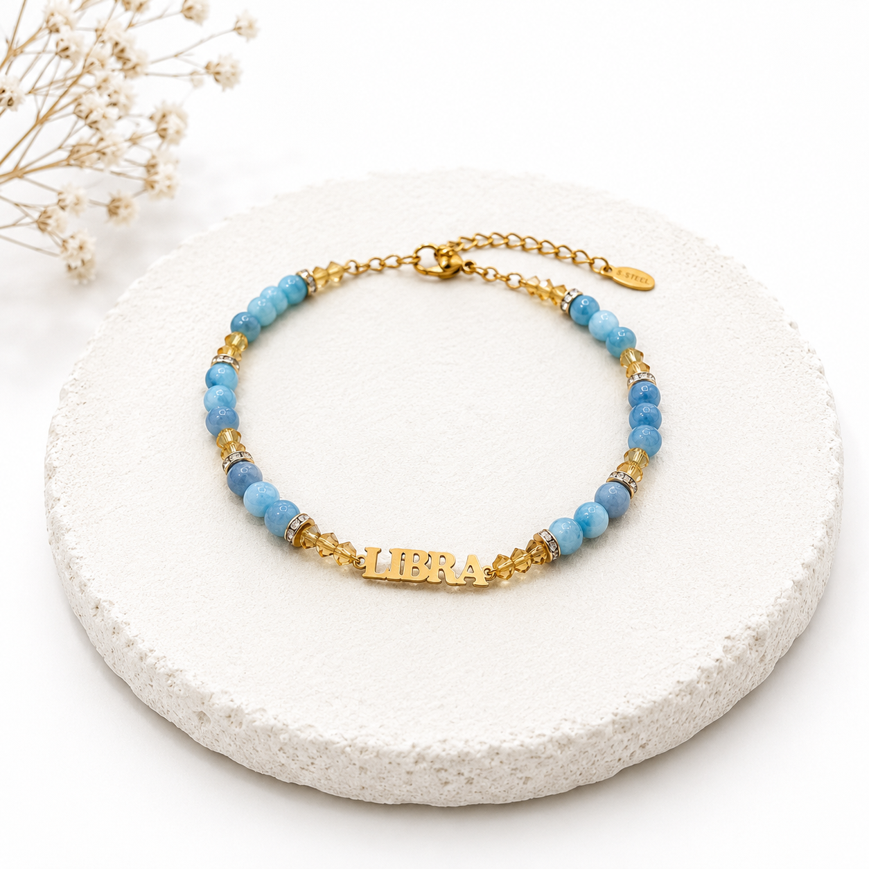 Bracelet with blue beads and gold accents on a white stone surface