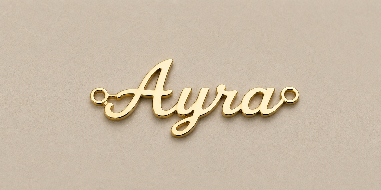 Gold nameplate with 'Ayra' on a beige background