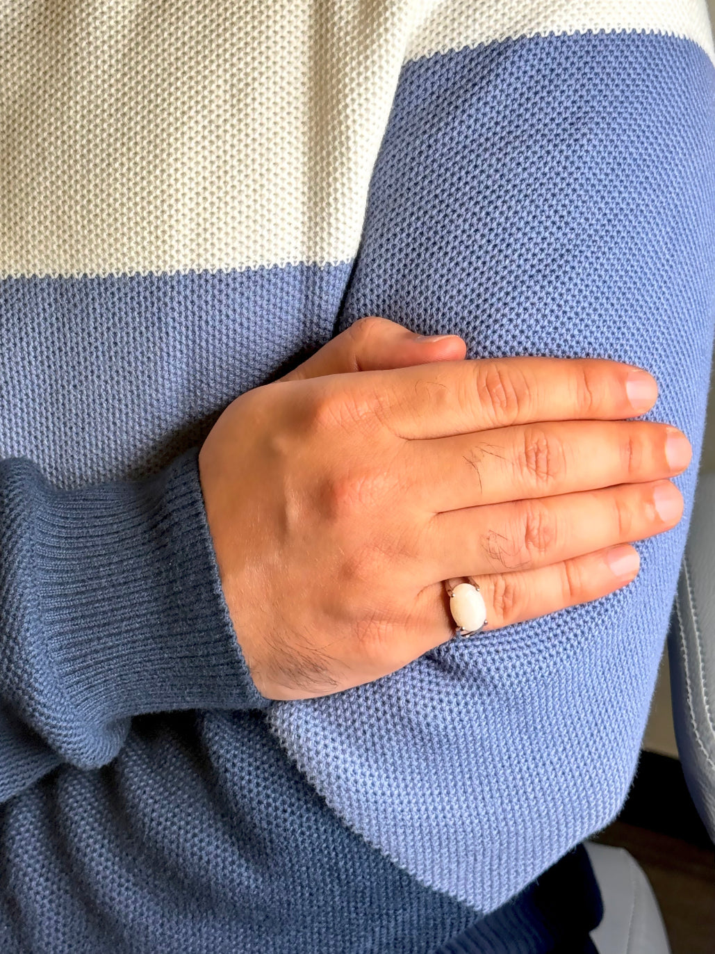 Close up of White Agate gemstone ring on a man’s hand
