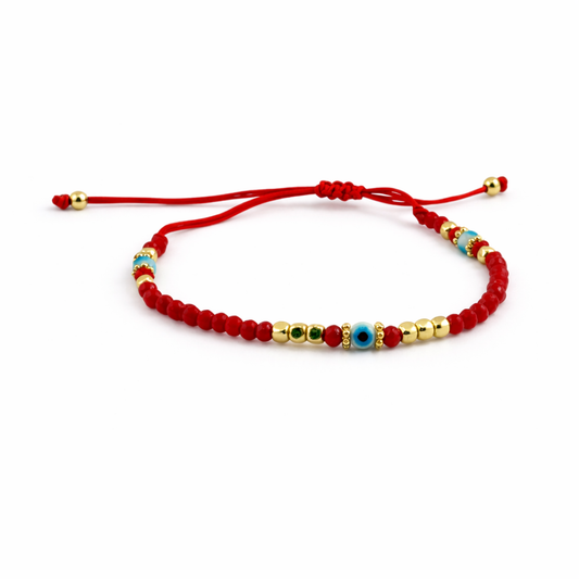 Red beaded bracelet with gold and blue beads on a white background