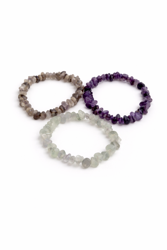 Three beaded bracelets in gray, purple, and clear on a white background