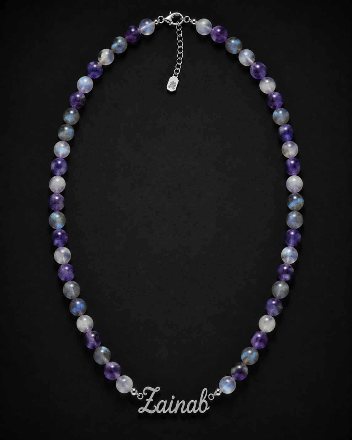 Necklace with multicolored beads and 'Lainab' clasp on a black background