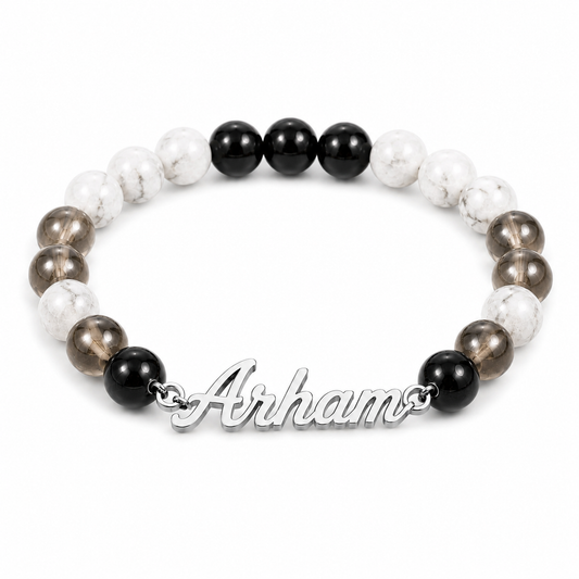 Bracelet with black, white, and brown beads and 'Arhams' clasp on a white background