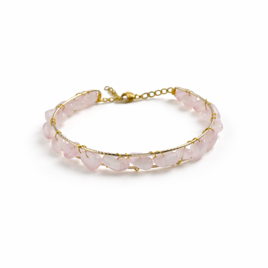 Bracelet with pink stones and gold chain on a white background