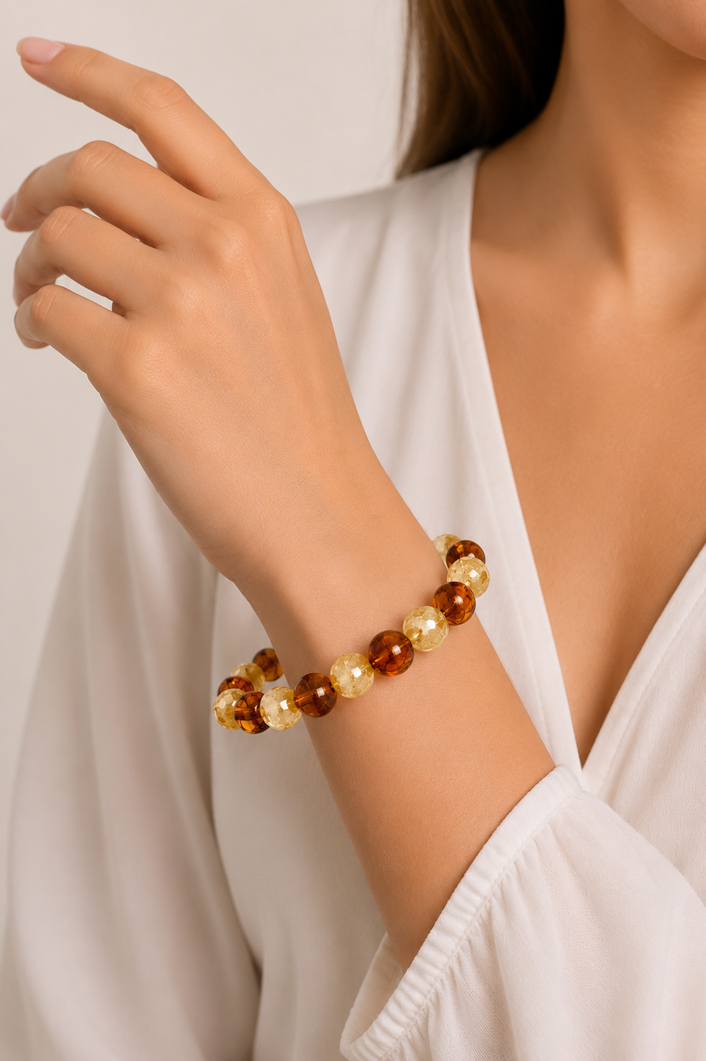 Close-up of a person wearing a beaded bracelet on a plain background