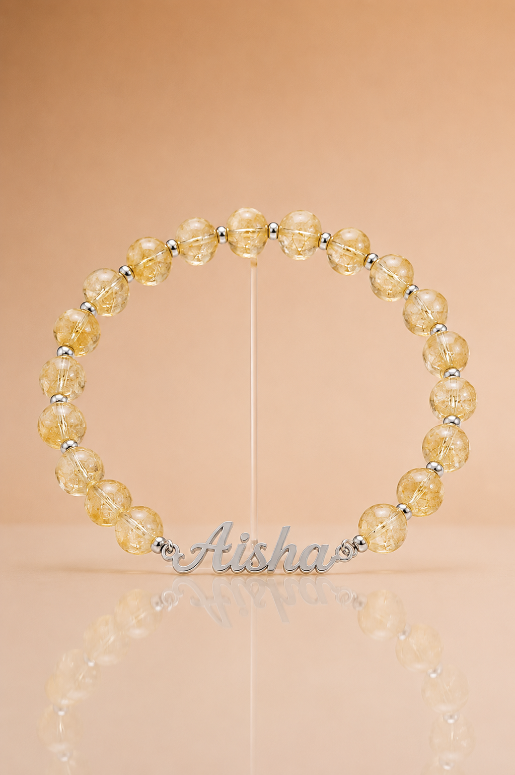 Beaded bracelet with yellow beads and silver accents on a beige background