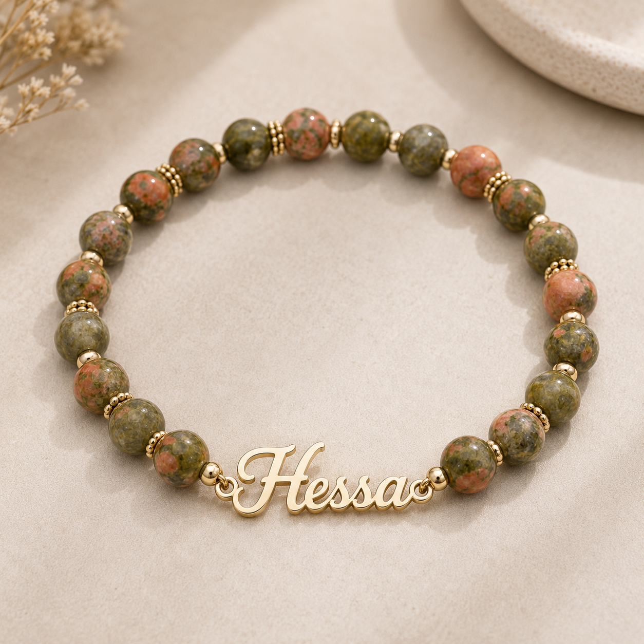 Beaded bracelet with gold name charm on a neutral background