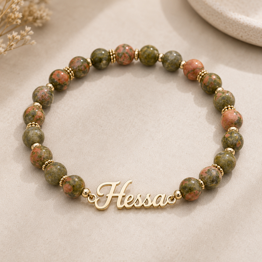 Beaded bracelet with gold name charm on a neutral background