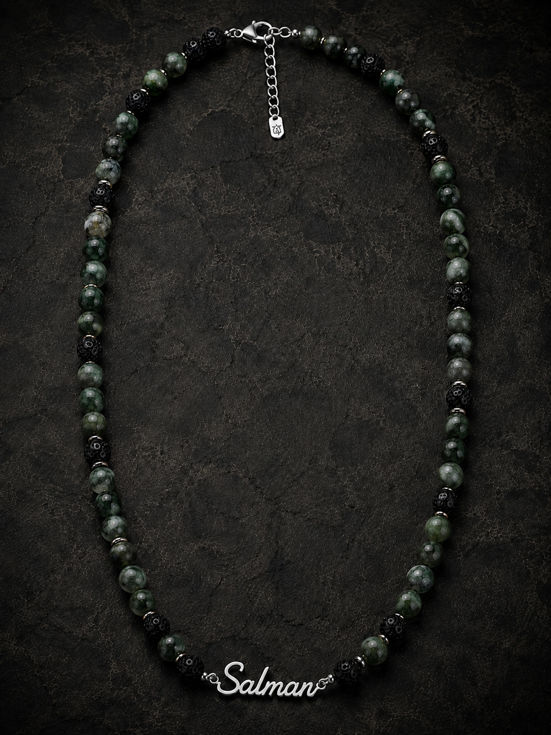 Necklace with black and green beads on a dark background