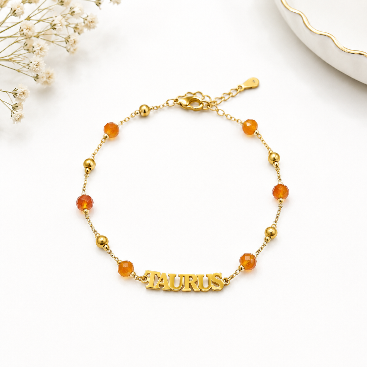 Gold bracelet with 'Taurus' charm on a white background