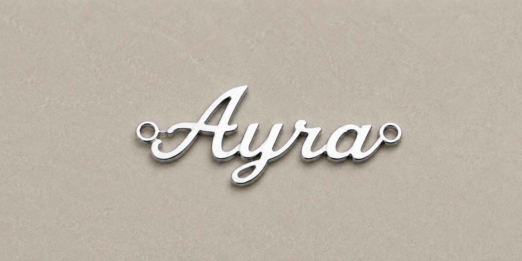 Silver nameplate with 'Ayra' on a beige background