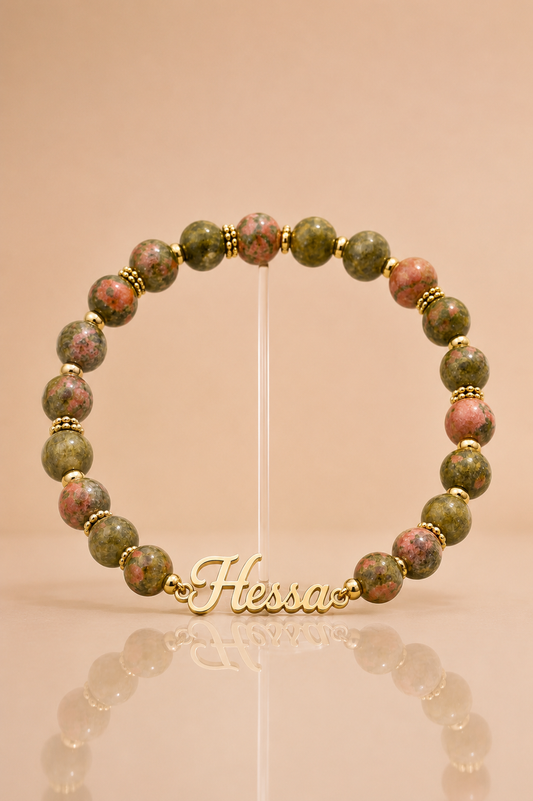 Beaded bracelet with gold accents on a stand, featuring the brand 'Hessia'.