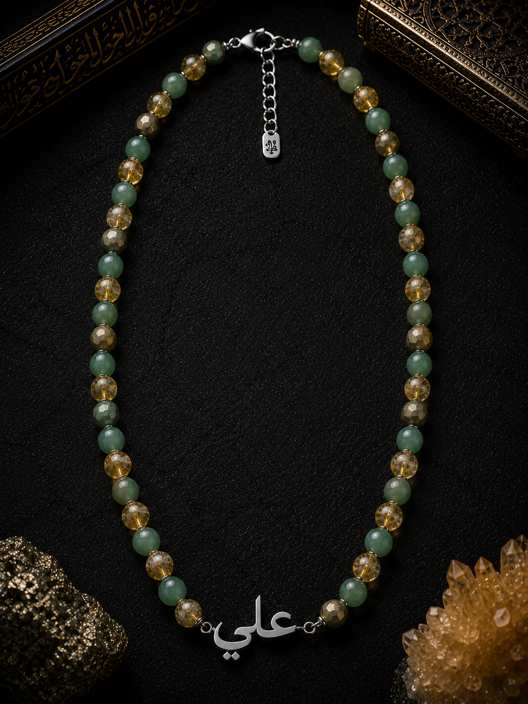 Beaded necklace with a silver charm on a dark textured surface