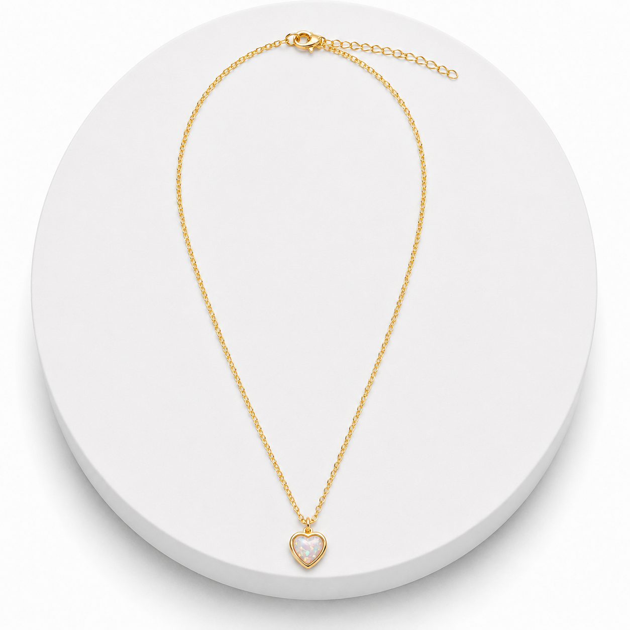 Gold necklace with a heart-shaped pendant on a white background