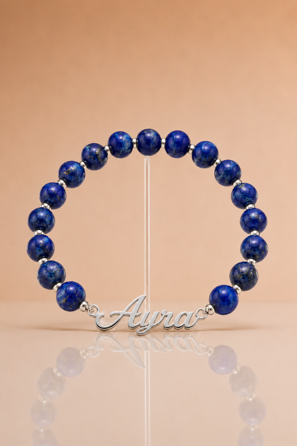 Blue beaded bracelet with a silver nameplate on a beige background