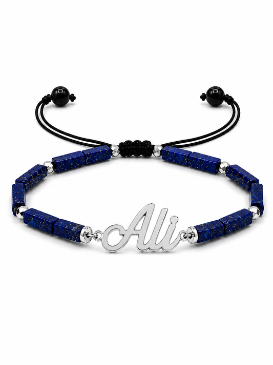 Bracelet with blue beads and a silver 'Ali' charm on a white background