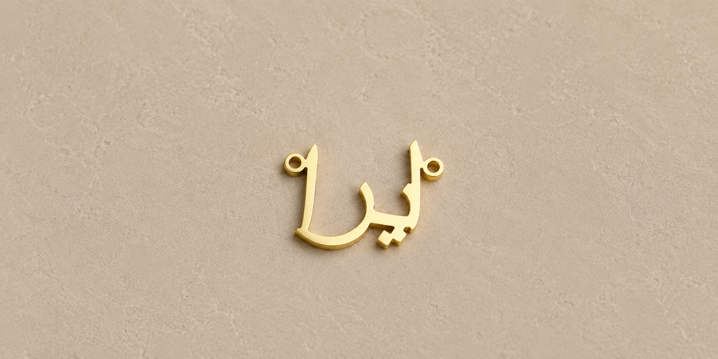 Gold Arabic letter charm on a beige background