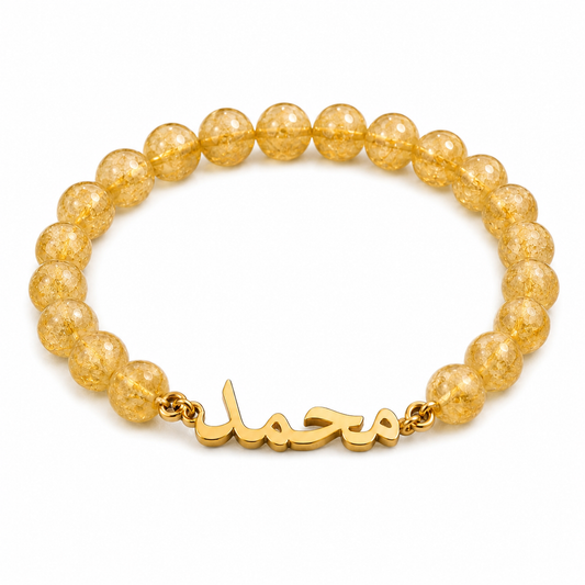 Gold beaded bracelet with a gold clasp on a white background