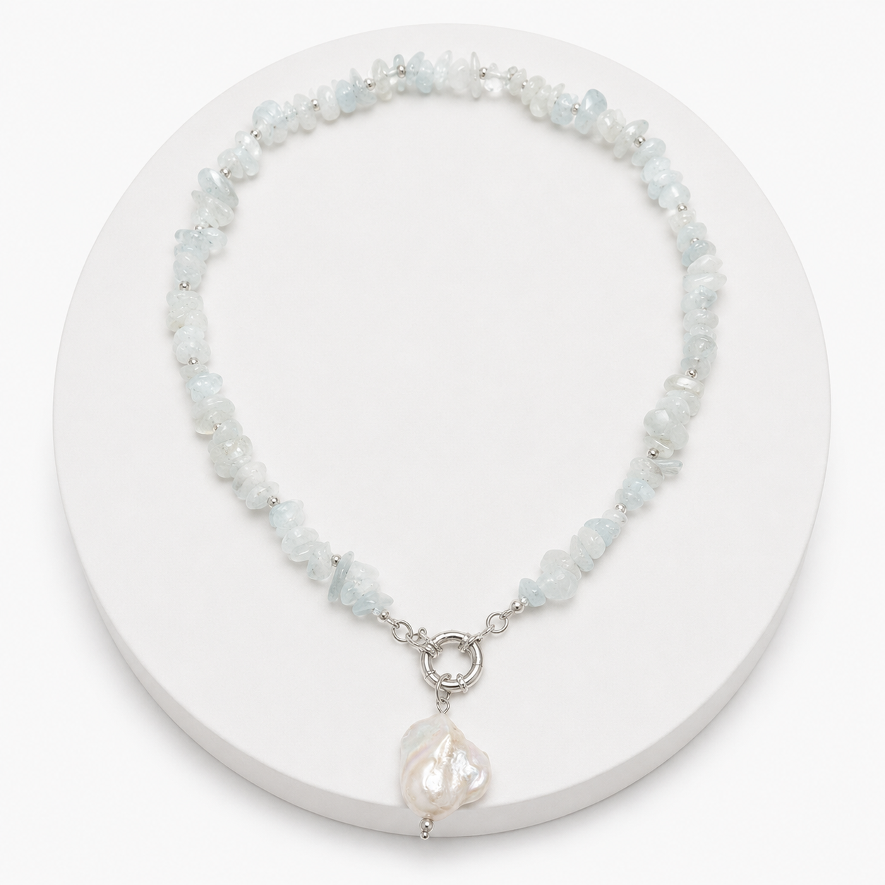 Necklace with light blue beads and a pearl pendant on a white background