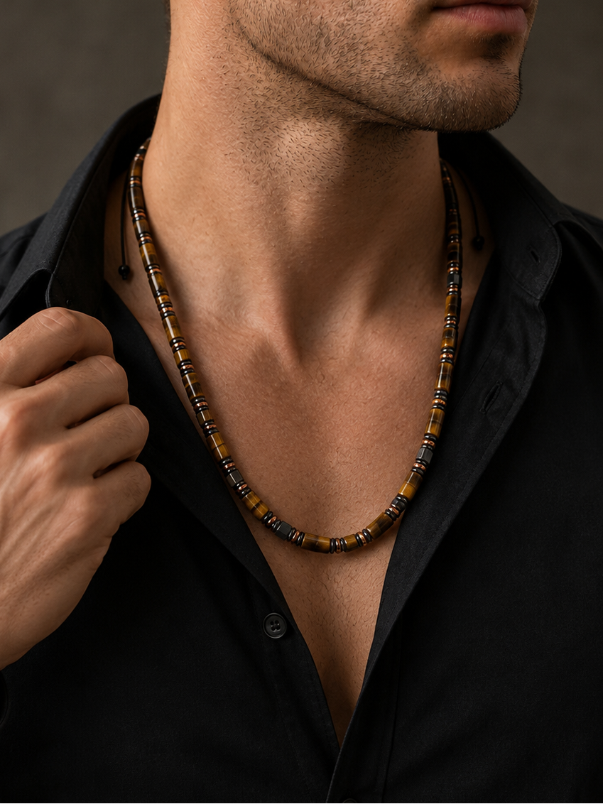 Man wearing a black shirt with a necklace against a neutral background