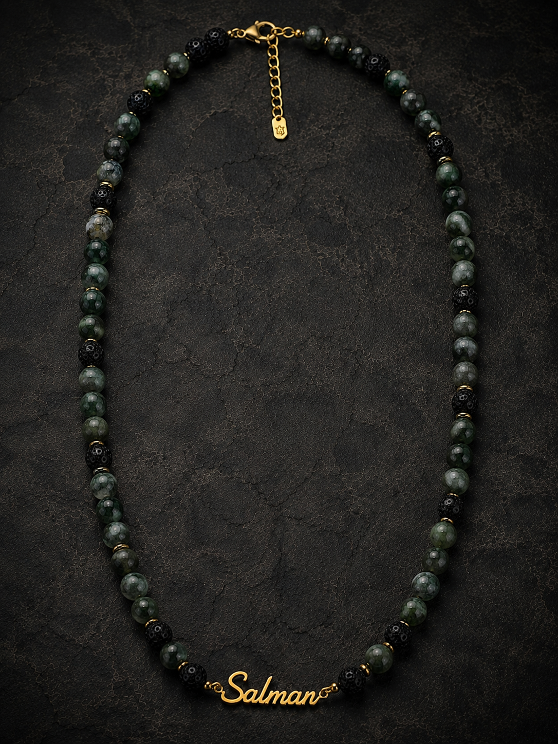 Necklace with black and gold beads on a dark textured background