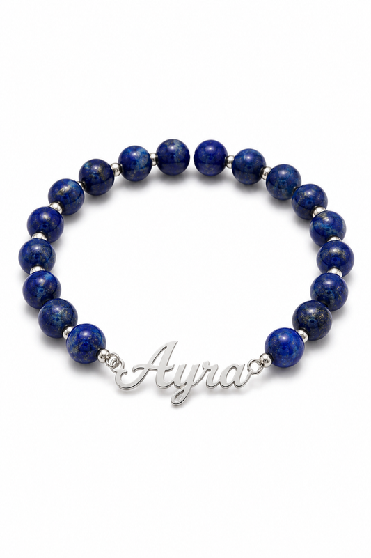 Blue beaded bracelet with a silver name charm on a white background