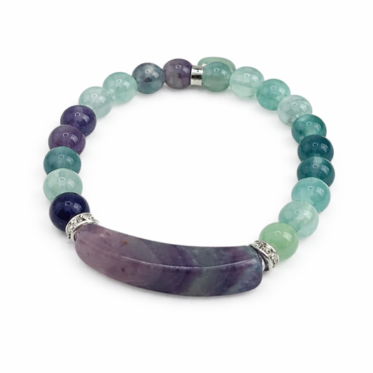 Multicolored beaded bracelet with a large purple stone on a white background