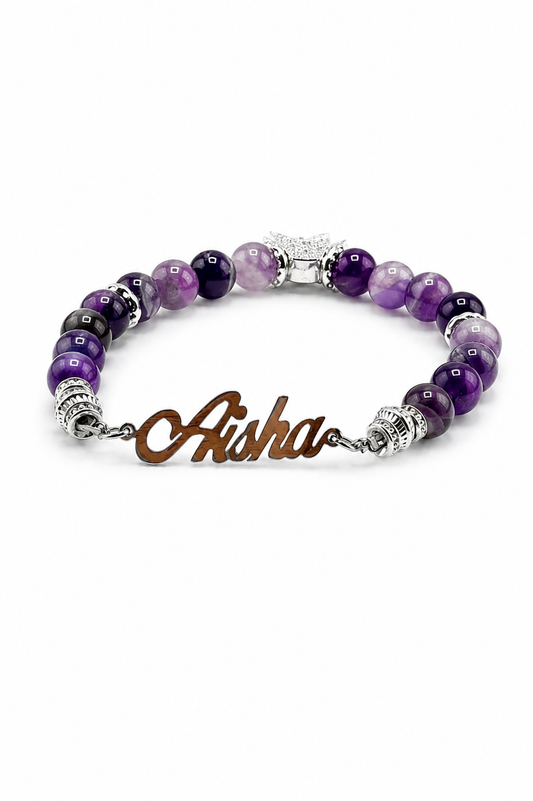 Purple beaded bracelet with a brown name charm on a white background