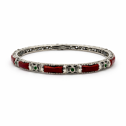 Silver bracelet with red and green accents on a white background
