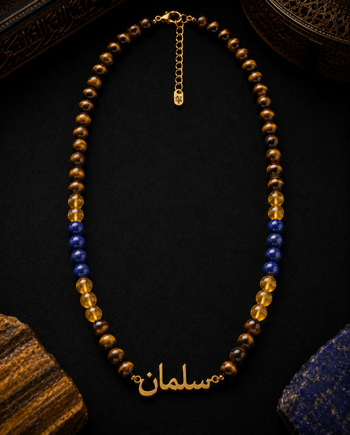 Necklace with gold, blue, and brown beads on a dark surface