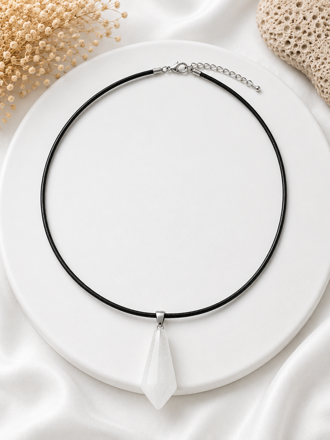 Necklace with a white pendant on a white plate