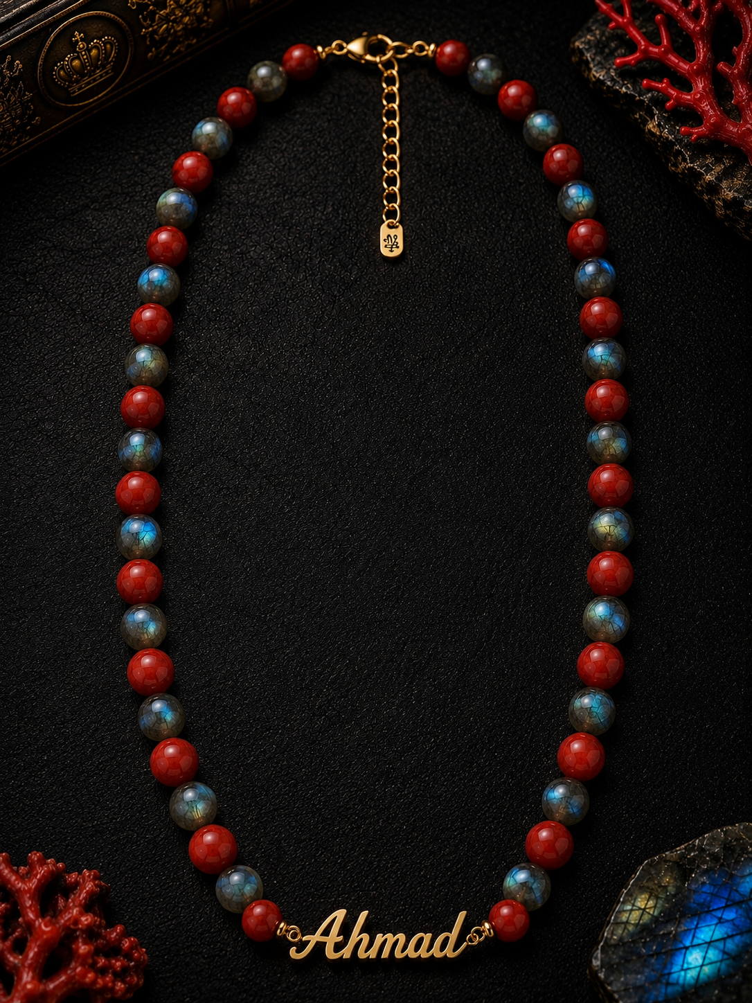 Beaded necklace with 'Ahmad' clasp on a dark surface