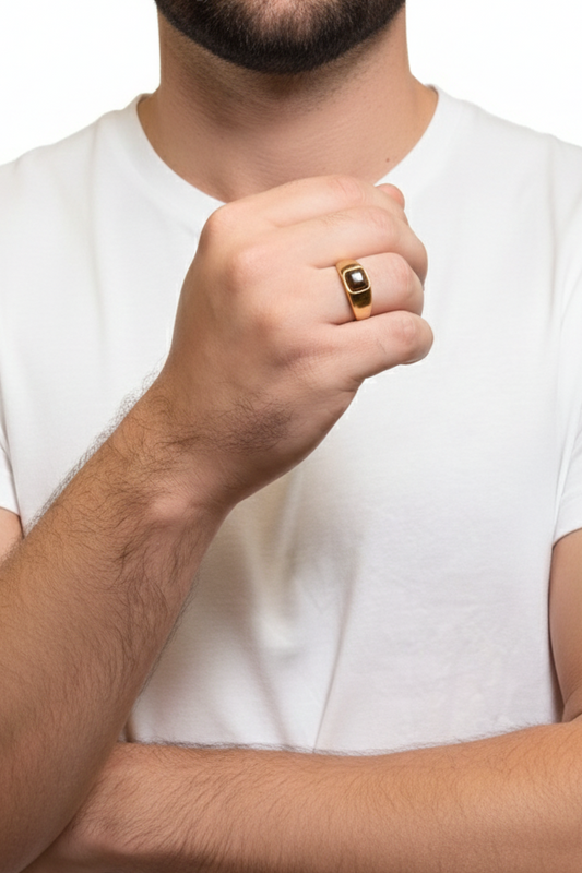 Man wearing a white t-shirt with a gold ring on his finger against a white background