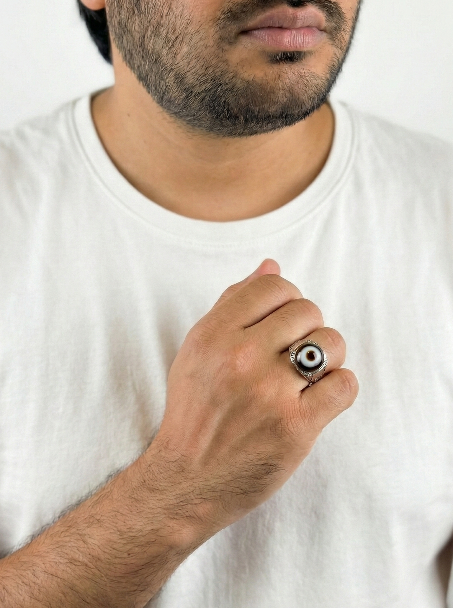 Man holding a small round object against a white background