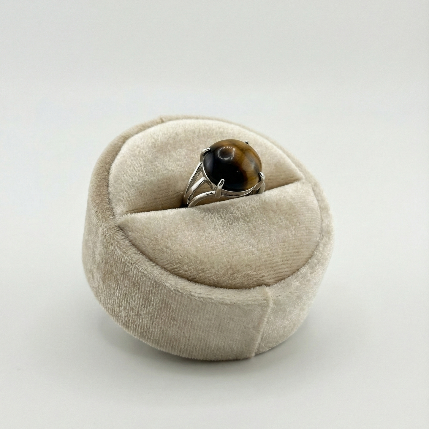 Beige ring box with a ring inside on a white background