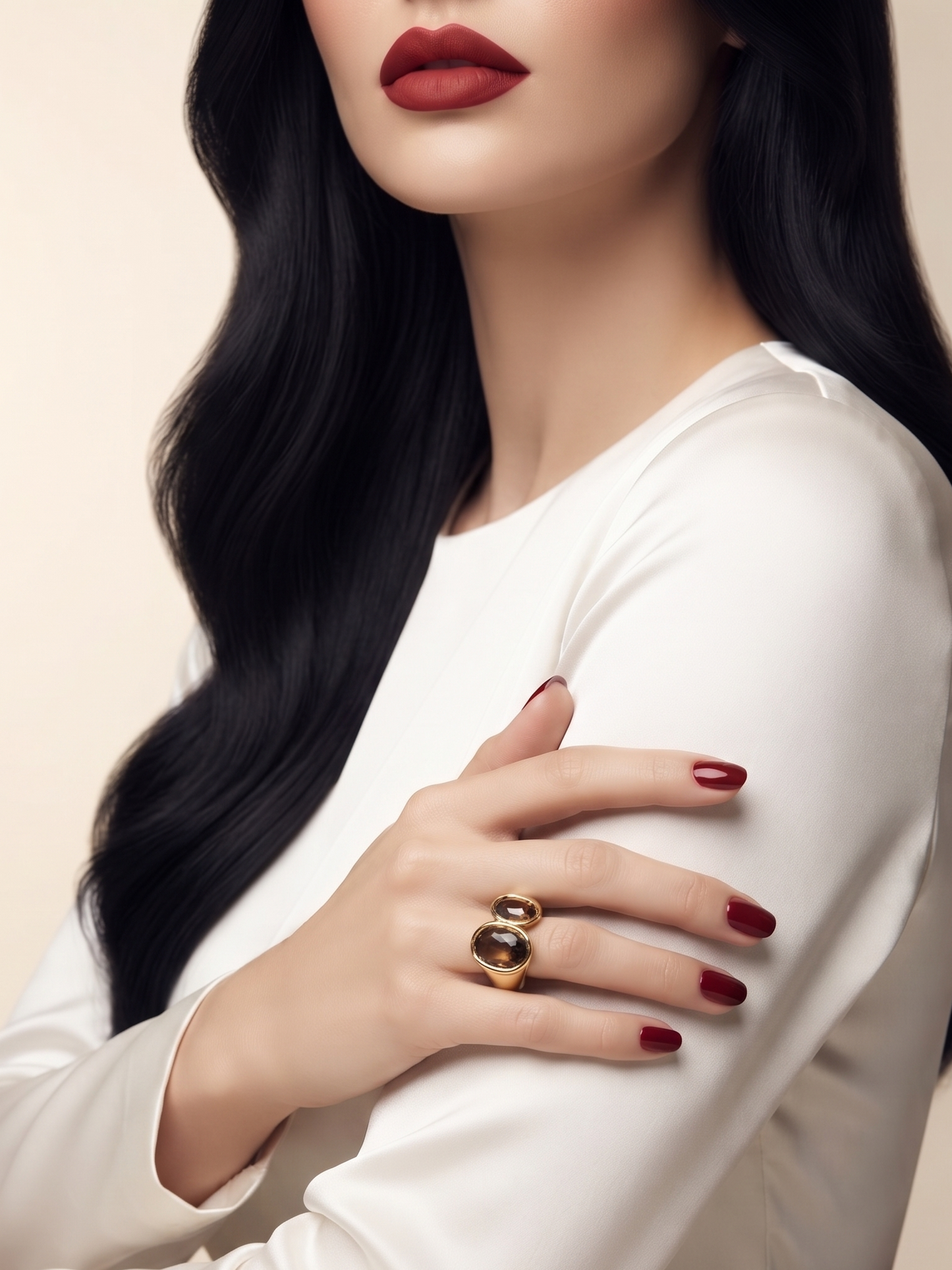 A close-up of a woman wearing a gold ring with a large oval black stone on her hand, which is resting on her white satin-sleeved blouse. She has long, wavy black hair and dark red lipstick.