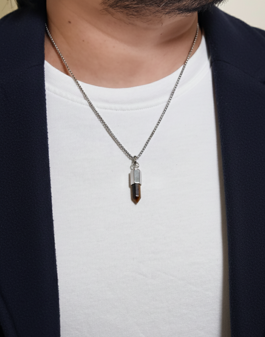 Necklace with a pendant worn by a person against a neutral background