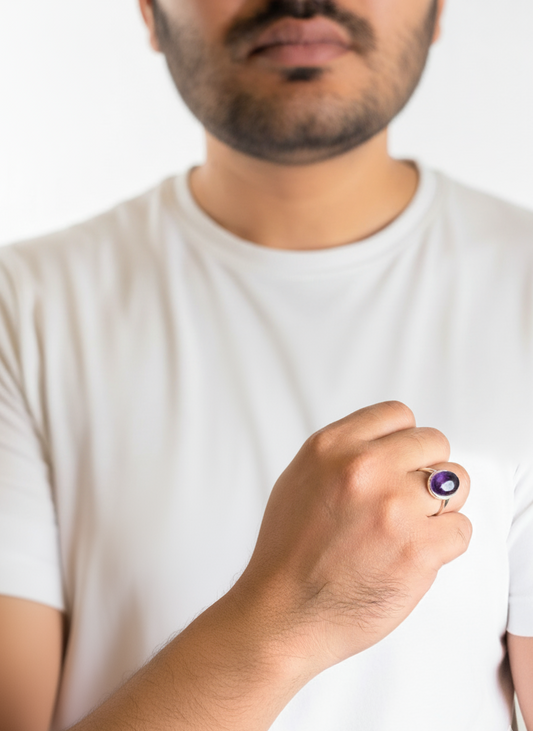 Man wearing a white t-shirt holding a small purple object.