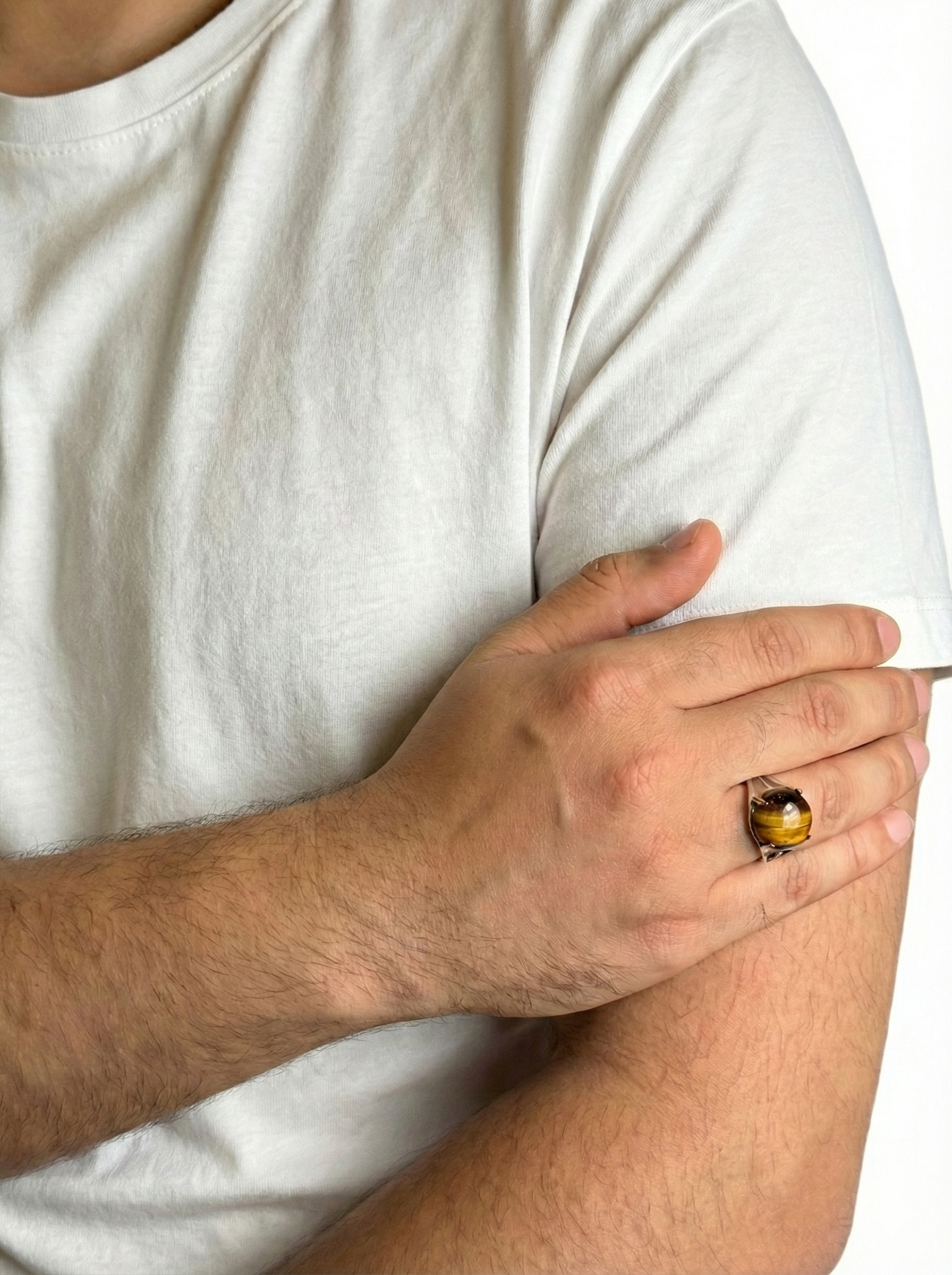 Person wearing a white t-shirt with a hand holding a small object near the elbow.