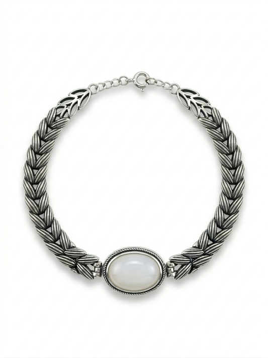 Silver braided necklace with a central stone on a white background